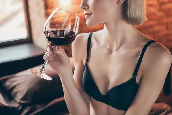 Reife Frau in eleganter Unterwäsche genießt ein Glas Rotwein – Symbol für selbstbewusste Erotik und sinnliche Sexkontakte reifer Frauen.